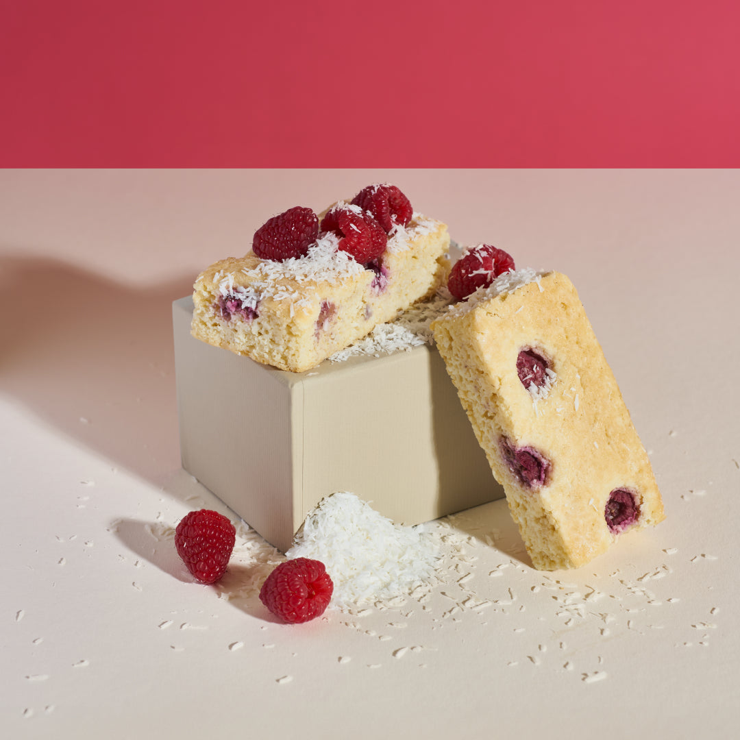 Kokos-Himbeer Kuchen ohne Zucker und Mehl drapiert mit Kokos und Himbeeren von PureCakes